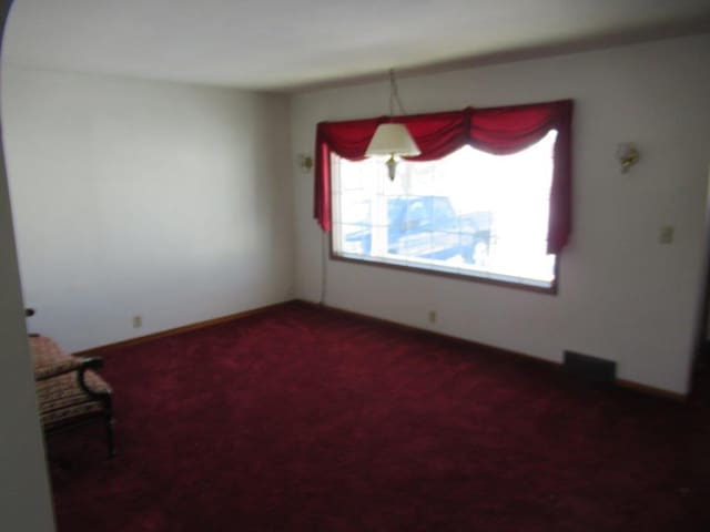 empty room featuring dark colored carpet