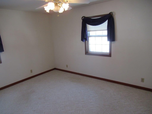 spare room featuring light carpet and ceiling fan