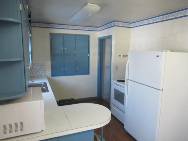 kitchen with blue cabinetry, sink, dark hardwood / wood-style floors, kitchen peninsula, and white appliances