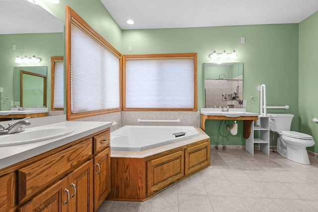 bathroom featuring tile patterned flooring, vanity, a bath, and toilet