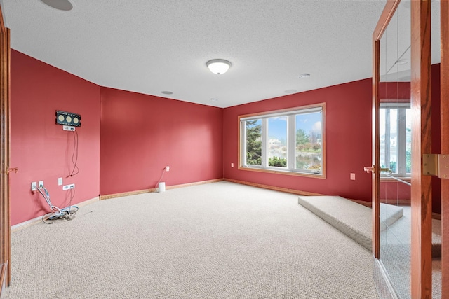 carpeted spare room with a healthy amount of sunlight and a textured ceiling