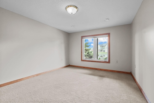 spare room with carpet flooring and a textured ceiling