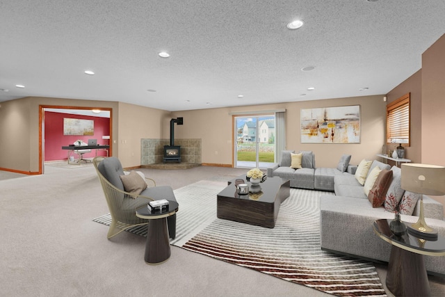 carpeted living room with a wood stove and a textured ceiling