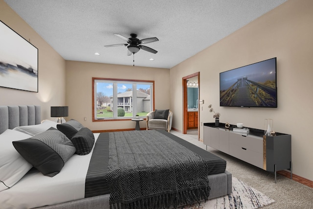 bedroom featuring connected bathroom, ceiling fan, light carpet, and a textured ceiling