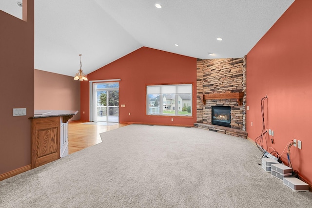 unfurnished living room featuring a fireplace, light carpet, a chandelier, and vaulted ceiling