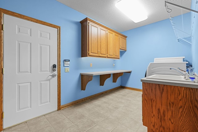 washroom with a textured ceiling and sink