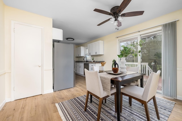 dining space featuring ceiling fan, sink, and light hardwood / wood-style flooring