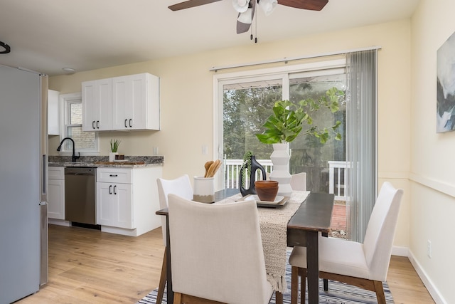 dining room featuring light wood-type flooring, ceiling fan, and sink