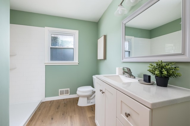 bathroom with walk in shower, toilet, vanity, and hardwood / wood-style flooring