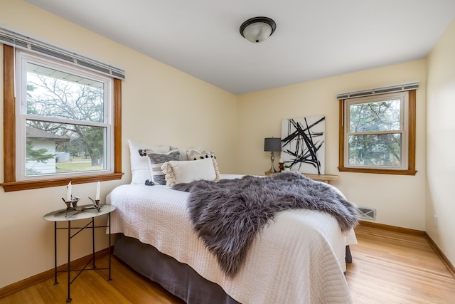 bedroom featuring light hardwood / wood-style flooring and multiple windows