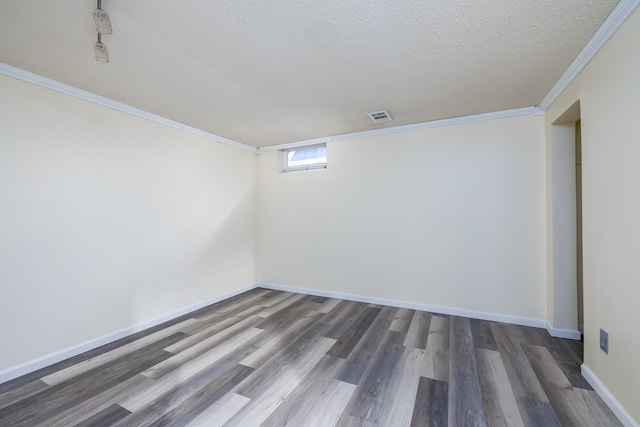 unfurnished room with ornamental molding, a textured ceiling, and dark wood-type flooring