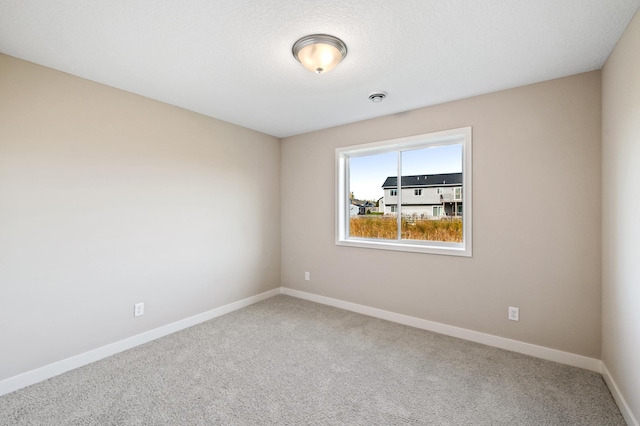 empty room with a textured ceiling and carpet flooring