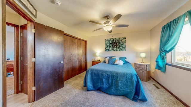 carpeted bedroom featuring a closet and ceiling fan