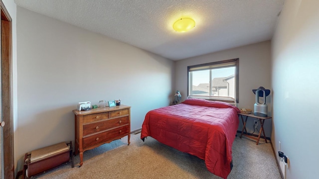 bedroom featuring a textured ceiling and light colored carpet