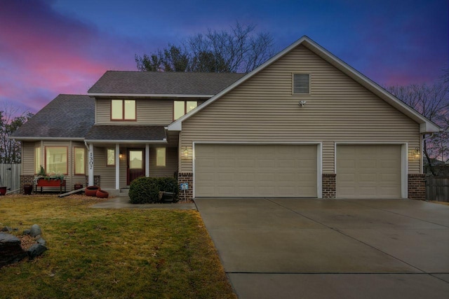 view of front of property featuring a garage, a lawn, concrete driveway, and brick siding