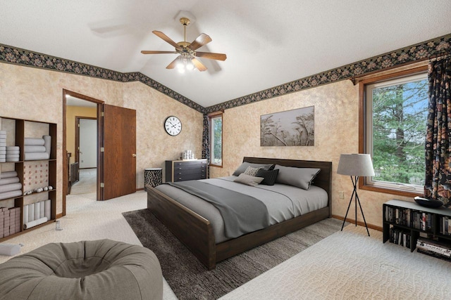 bedroom featuring lofted ceiling, wallpapered walls, carpet, and baseboards