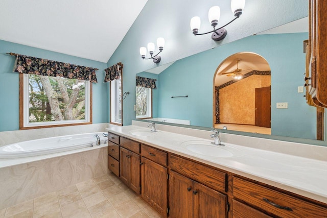 full bathroom featuring lofted ceiling, a garden tub, a sink, and double vanity