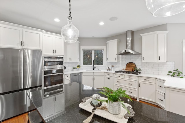 kitchen featuring sink, white cabinets, wall chimney exhaust hood, and stainless steel appliances