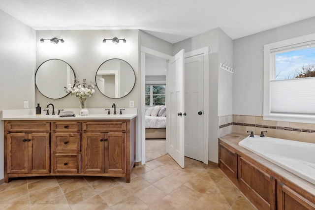 bathroom featuring a washtub, a wealth of natural light, and vanity