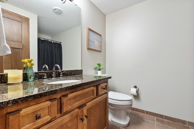 bathroom featuring a textured ceiling, toilet, tile patterned floors, and vanity