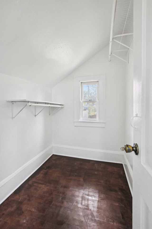 walk in closet featuring dark wood-type flooring and lofted ceiling