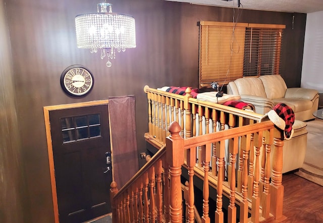 stairs featuring hardwood / wood-style floors and an inviting chandelier