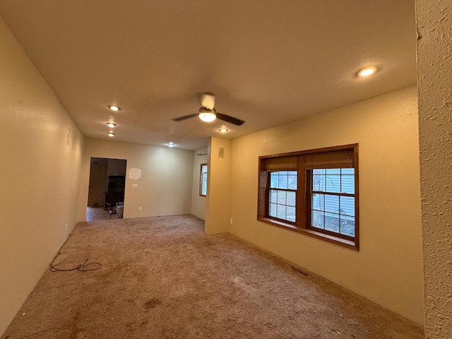 spare room featuring carpet and ceiling fan