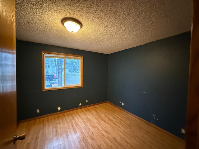 spare room with wood-type flooring and a textured ceiling