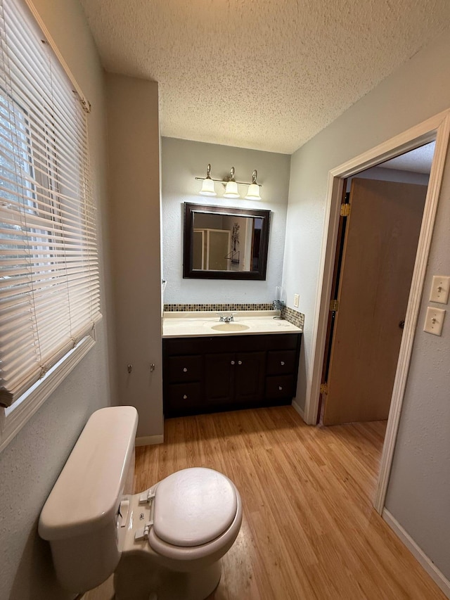 bathroom with vanity, wood-type flooring, a textured ceiling, and toilet