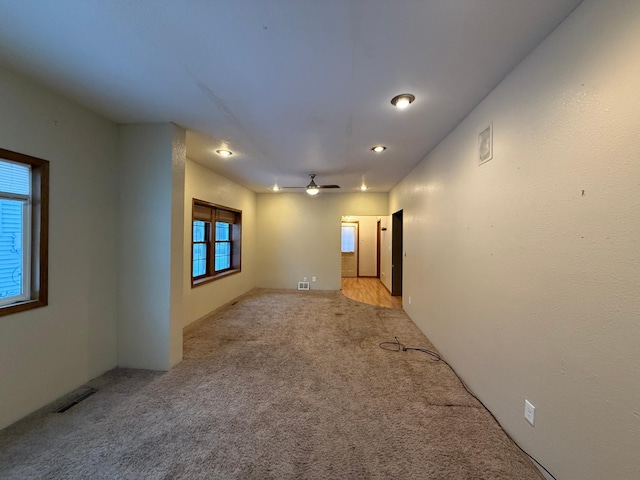 carpeted spare room featuring ceiling fan