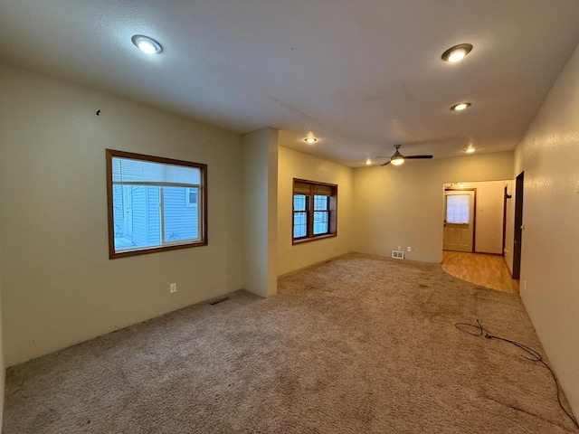 carpeted spare room with ceiling fan