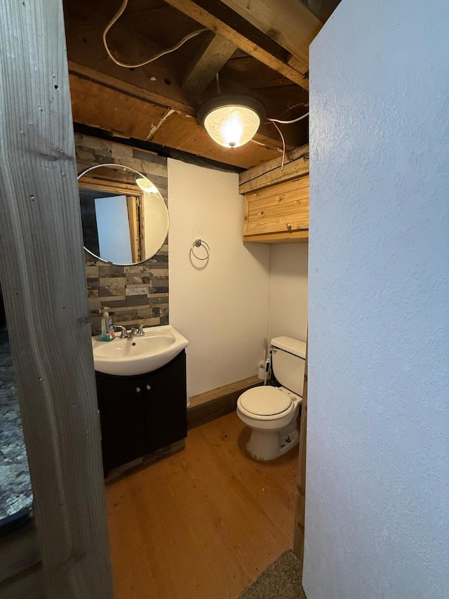 bathroom with vanity, toilet, and wood-type flooring