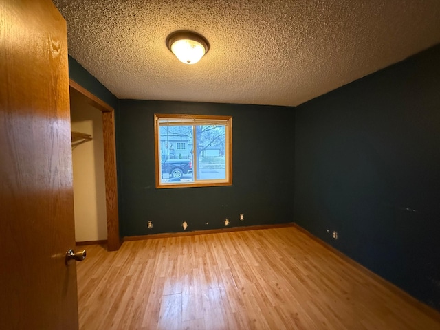 unfurnished bedroom featuring a textured ceiling and hardwood / wood-style flooring