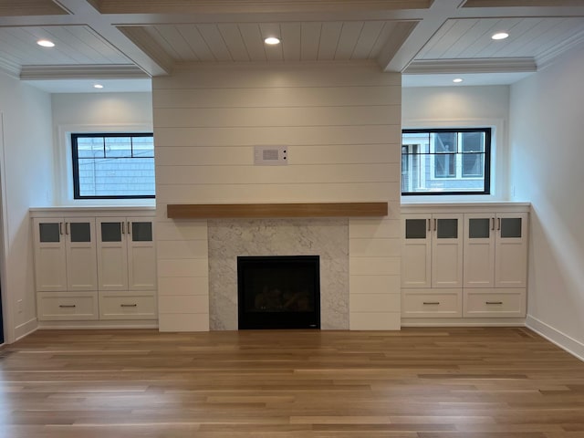 unfurnished living room with beam ceiling, crown molding, a fireplace, recessed lighting, and wood finished floors