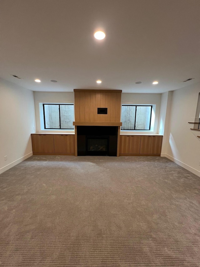 unfurnished living room featuring carpet floors, a fireplace, recessed lighting, visible vents, and baseboards