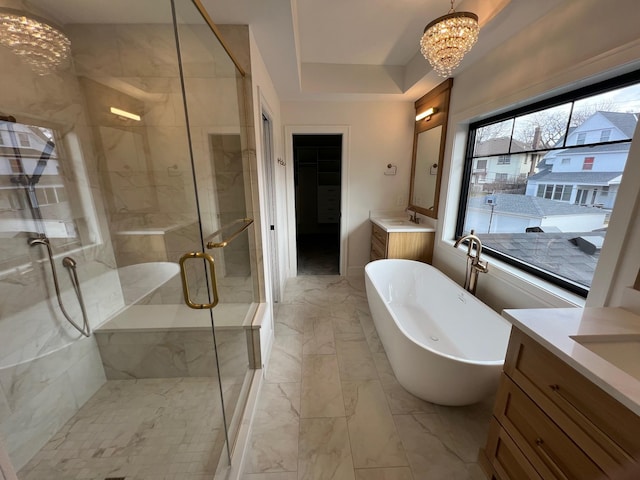 bathroom featuring a notable chandelier, vanity, a freestanding bath, marble finish floor, and a stall shower