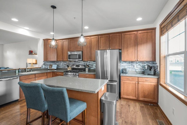 kitchen featuring stainless steel appliances, dark wood-type flooring, pendant lighting, and tasteful backsplash