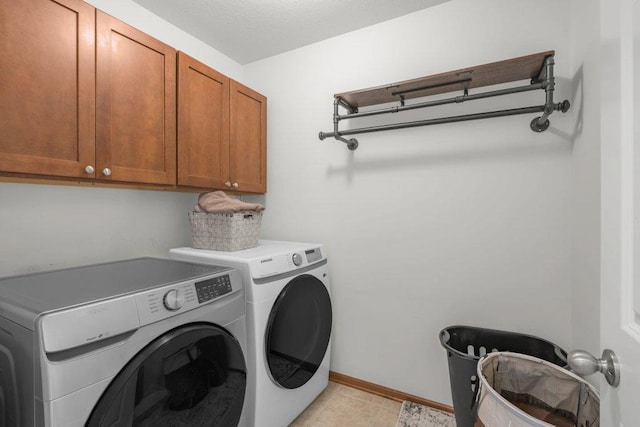 washroom with cabinets, light tile patterned flooring, and washer and clothes dryer