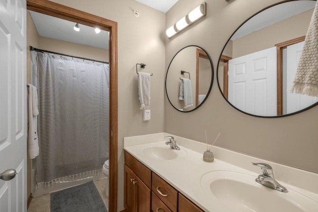 bathroom with toilet, vanity, and curtained shower