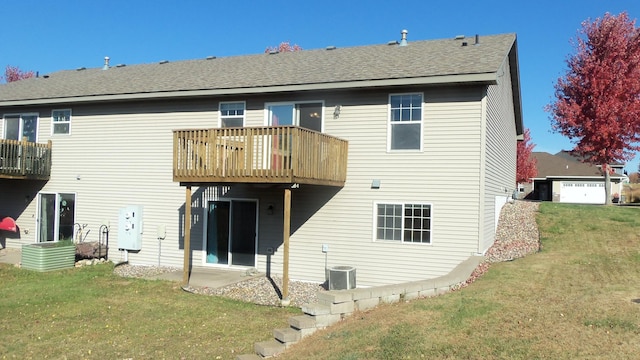 rear view of property featuring cooling unit, a balcony, and a yard