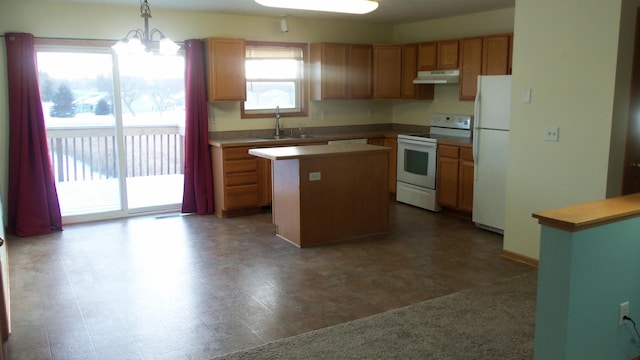 kitchen with white appliances, sink, pendant lighting, a notable chandelier, and a kitchen island