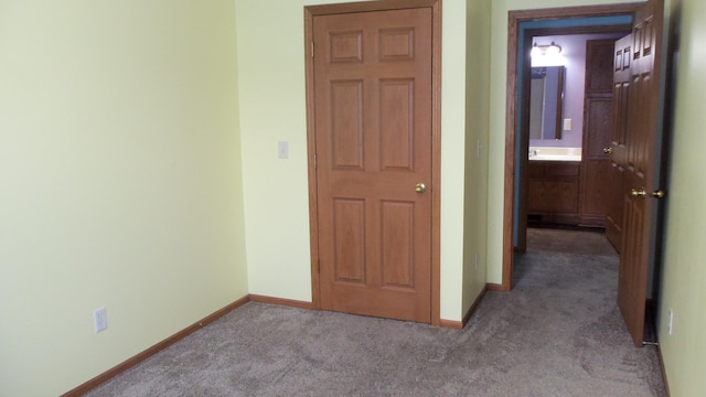 interior space featuring ensuite bathroom and light colored carpet