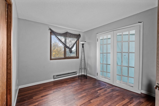 empty room featuring french doors, a textured ceiling, baseboard heating, and dark wood-type flooring