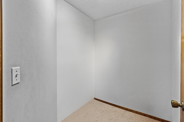 unfurnished room featuring a textured ceiling and carpet floors