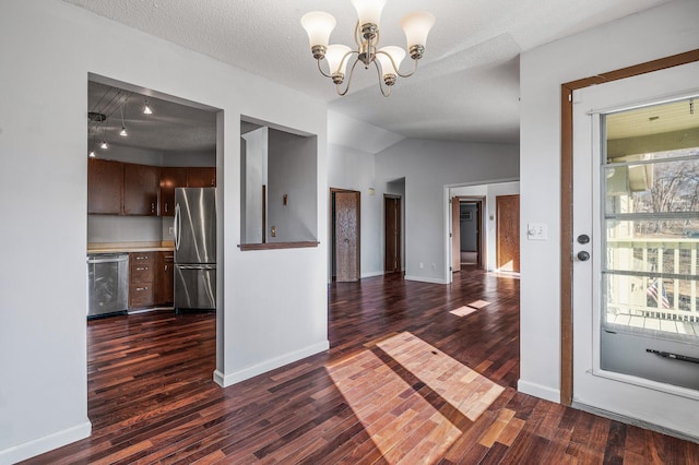 spare room with dark wood-style flooring, a notable chandelier, and baseboards