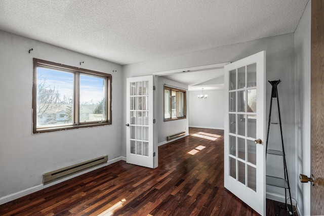 empty room featuring a baseboard heating unit, french doors, wood finished floors, and a notable chandelier