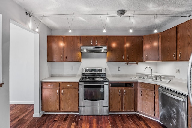 kitchen featuring under cabinet range hood, appliances with stainless steel finishes, light countertops, and dark wood-style flooring