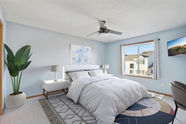 carpeted bedroom featuring ceiling fan and a textured ceiling