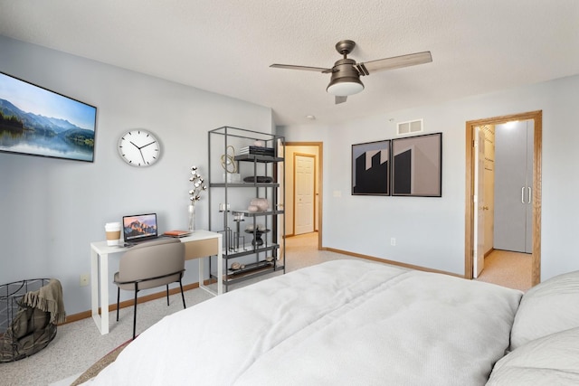 bedroom featuring ceiling fan, light colored carpet, and a textured ceiling