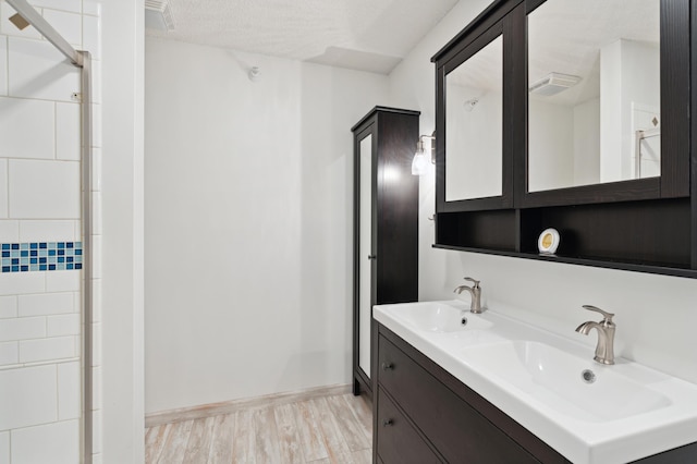 bathroom with vanity, hardwood / wood-style floors, and a textured ceiling